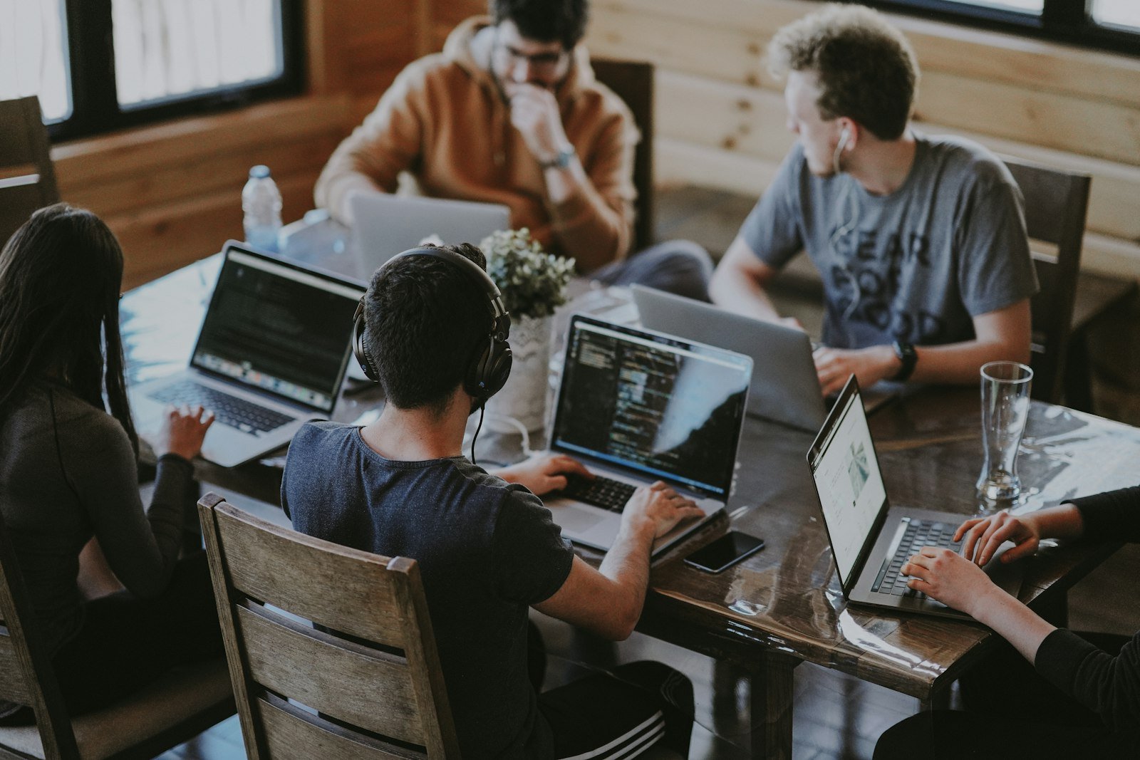 Small business team reviewing shared data on laptops around a table
